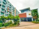 Modern residential apartment building entrance with lush greenery