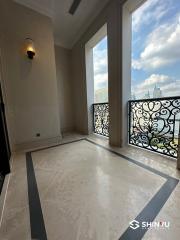 Spacious balcony with wrought iron railing and marble flooring overlooking the city