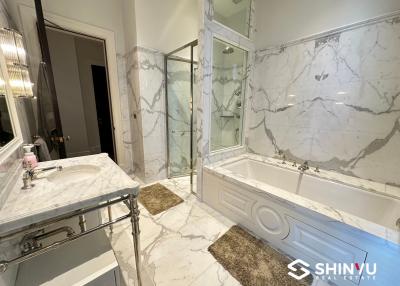 Luxurious marble bathroom with large tub and glass-enclosed shower