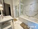 Luxurious marble bathroom with large tub and glass-enclosed shower