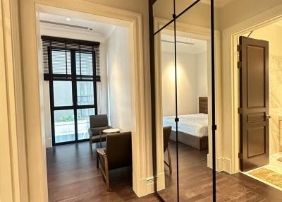 Elegant bedroom with wooden flooring and en-suite bathroom viewed from hallway