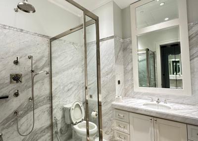 Modern bathroom with marble tiles and glass shower enclosure