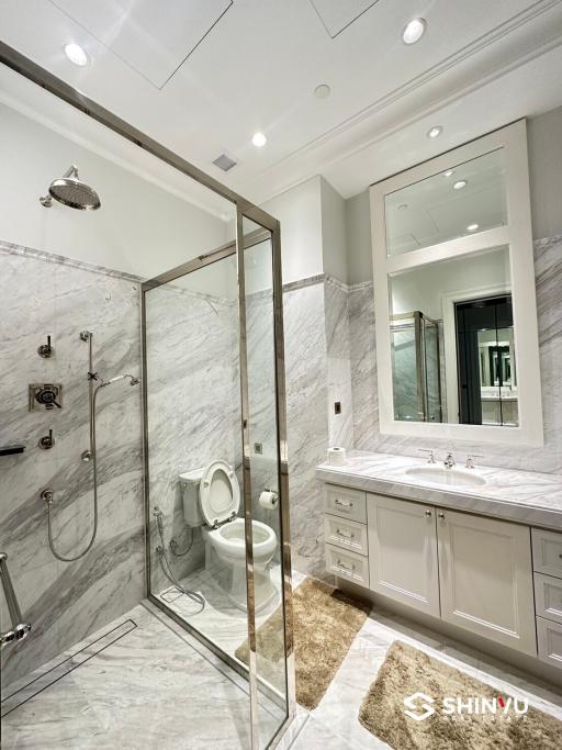 Modern bathroom with marble tiles and glass shower enclosure