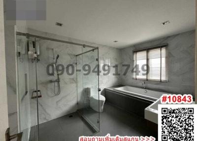 Spacious modern bathroom with glass shower enclosure and bathtub