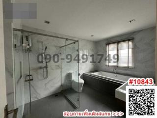 Spacious modern bathroom with glass shower enclosure and bathtub