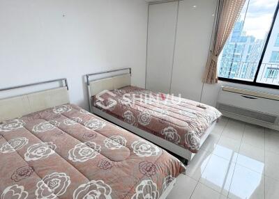 Modern bedroom with twin beds and large window.