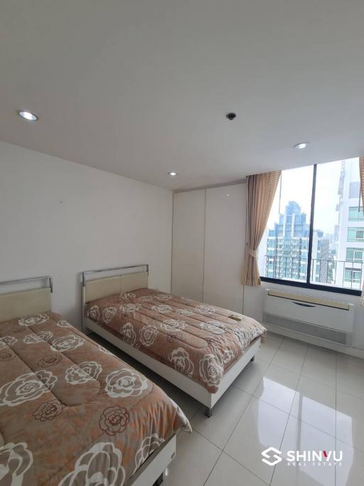 Spacious bedroom with two single beds and large window