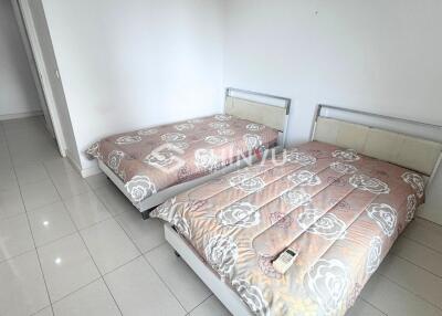 Bedroom with two beds and white tiled floor