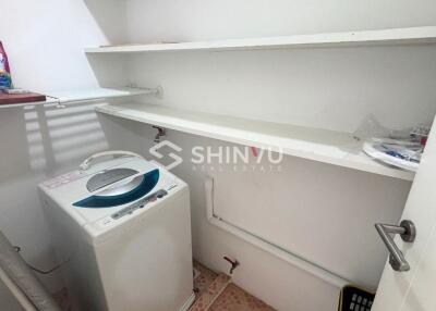 Laundry room with washing machine and shelves