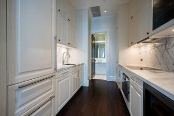 Modern kitchen with white cabinetry and marble countertops