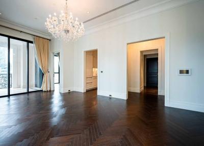 Spacious living room with dark hardwood floors and a crystal chandelier