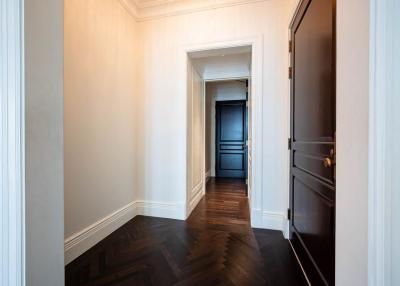 Elegant hallway with herringbone wood flooring leading to an interior room