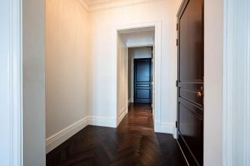 Elegant hallway with herringbone wood flooring leading to an interior room