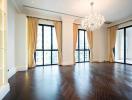 Spacious living room with large windows and chandelier