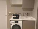 Compact laundry room with modern washer and dryer, cabinets and sink