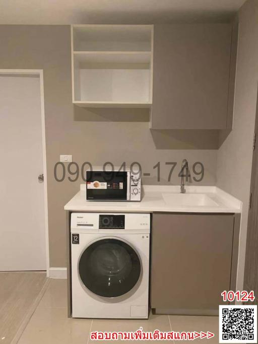 Compact laundry room with modern washer and dryer, cabinets and sink