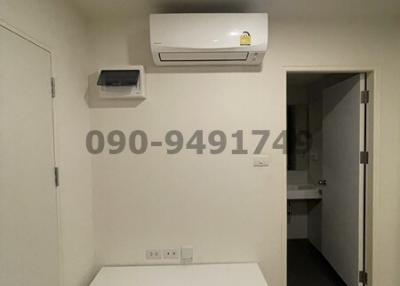 Minimalistic room with air conditioning unit and white storage furniture