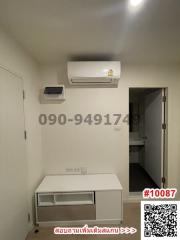 Minimalistic room with air conditioning unit and white storage furniture