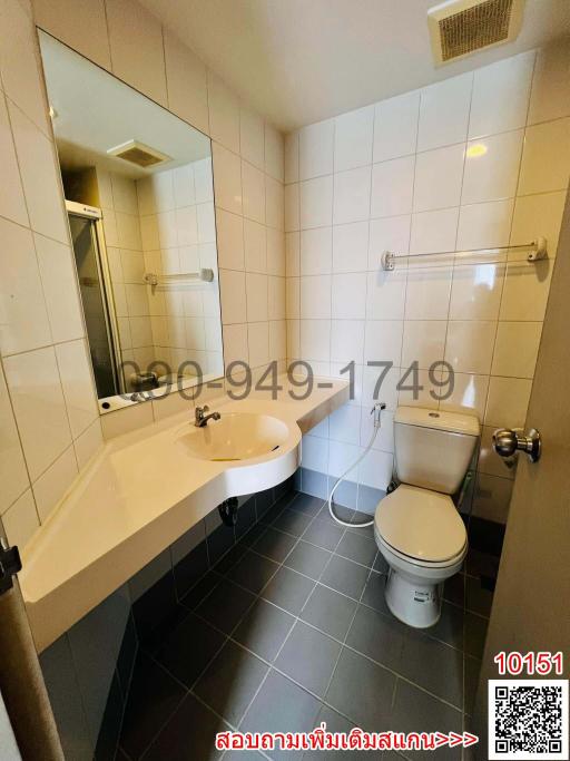 Compact bathroom with white tiles, toilet, and sink