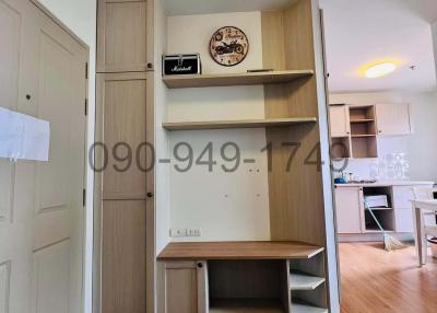 Compact interior view of a furnished room with built-in shelves and cabinets