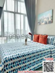 Cozy bedroom with city view through large windows and patterned bedding