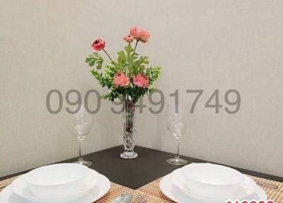 Elegantly set table for two in a modern dining area with flowers centerpiece