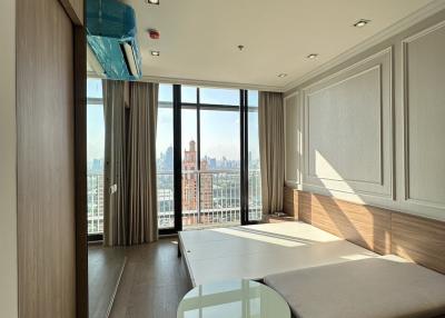 Spacious bedroom with large windows and city view