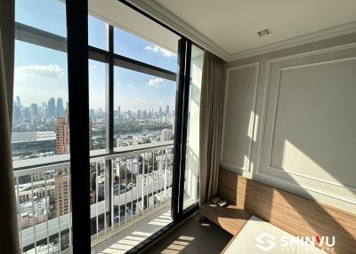 Bright bedroom with large windows and city view