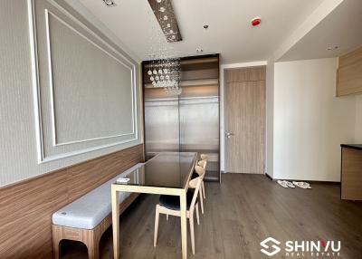 Modern dining room with table, bench, and elegant light fixture