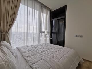 Cozy bedroom with large window and white bedding