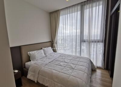 Spacious bedroom with a large window and ample natural light