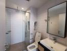 Modern bathroom interior with glass shower and white tiles