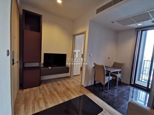 Modern living area with hardwood flooring, dining table, and TV