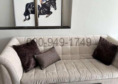 Modern living room with comfortable beige sofa and equestrian-themed wall art