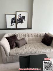 Modern living room with comfortable beige sofa and equestrian-themed wall art