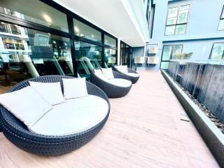 Spacious modern balcony with comfortable seating and a view of the building
