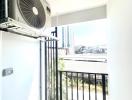 Sunny balcony with air conditioning unit and urban view