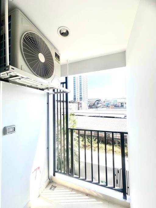 Sunny balcony with air conditioning unit and urban view