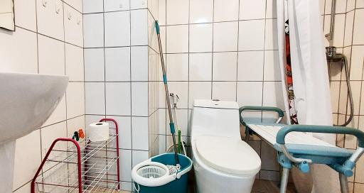 Compact bathroom with white tiling and basic fixtures