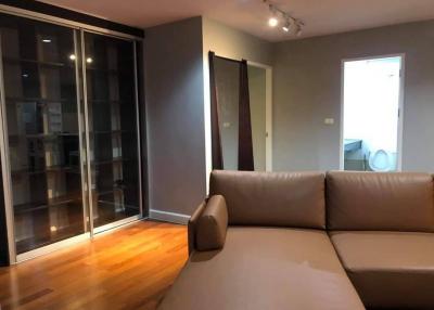 Spacious living room with hardwood flooring and glass doors leading to balcony