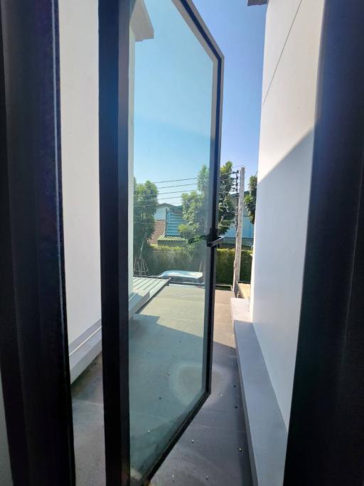 View through an open door leading to an outdoor patio area with clear skies