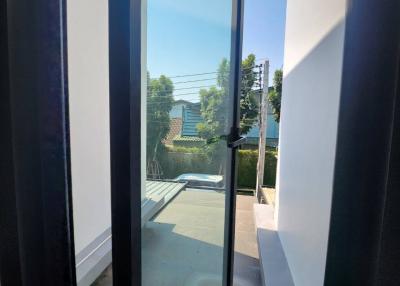 View through an open door leading to an outdoor patio area with clear skies