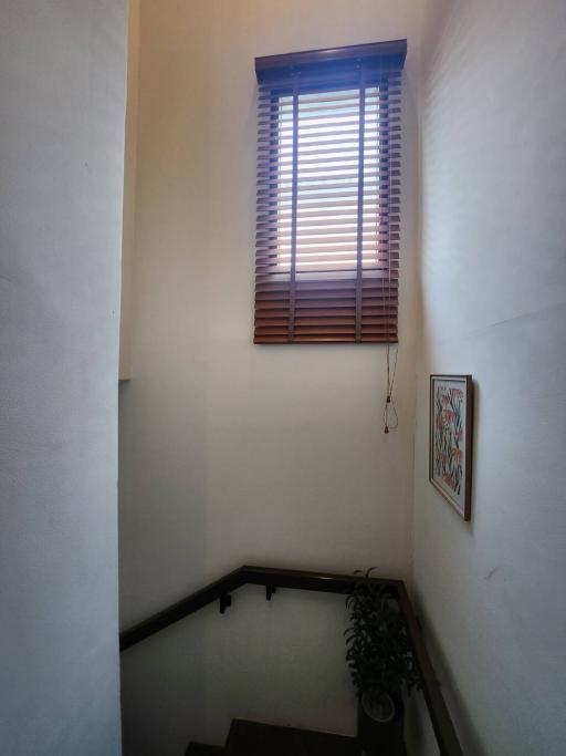 Staircase with natural light coming through a window with blinds