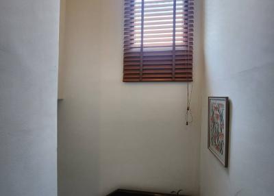 Staircase area with wooden blinds, natural light, and a decorative painting