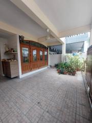 Spacious patio area with tile flooring and wooden-framed glass doors