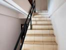 Clean staircase with white tiles and black railing