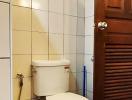 Compact bathroom with white ceramic tiles and wooden cabinet
