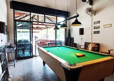 Spacious recreation room with pool table and high ceiling