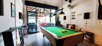 Spacious recreation room with pool table and high ceiling