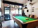 Spacious recreation room with pool table and high ceiling